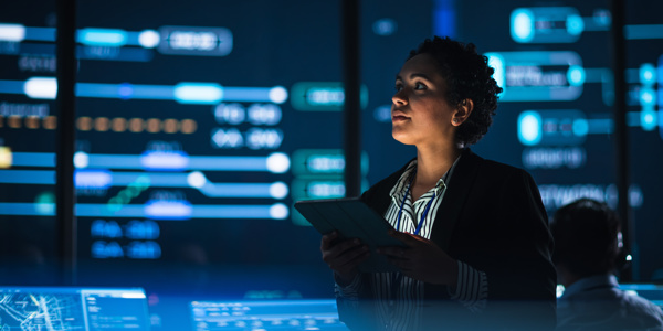 Business woman in data room looking at screens