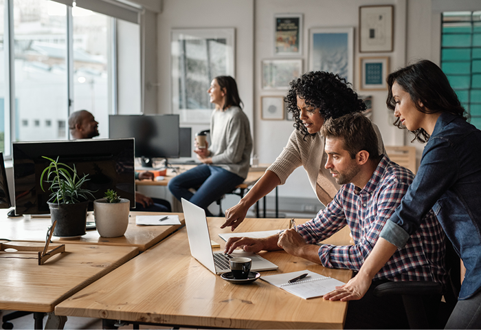Three professional people working in a shared office space