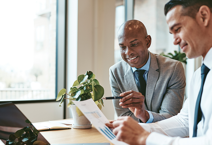 Two business men discussing a chart in office